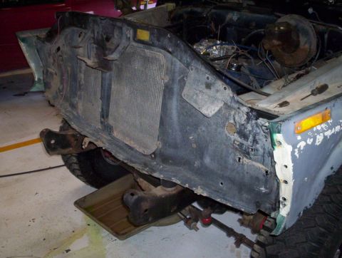 1978 Ford Bronco - The front end of a 1978 Ford Bronco is shown with the radiator removed, revealing the engine bay and surrounding components.