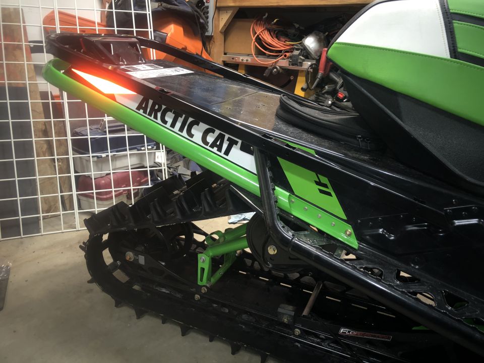 Rear view of a snowmobile with "Arctic Cat" branding and green accents