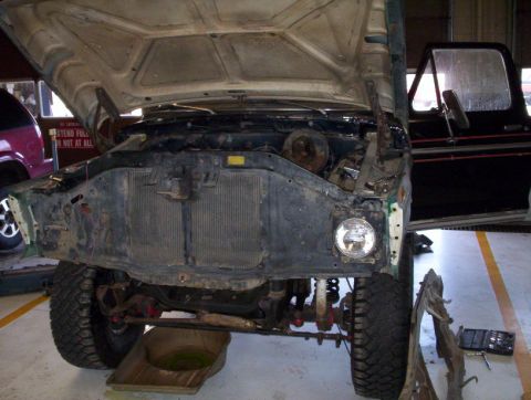 1978 Ford Bronco - Front view of a 1978 Ford Bronco undergoing repairs with its hood and front end components removed.