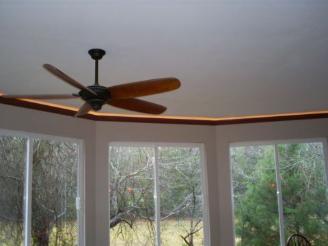 1992 Ford Bronco - A ceiling fan is visible above windows that look out onto a wooded area.