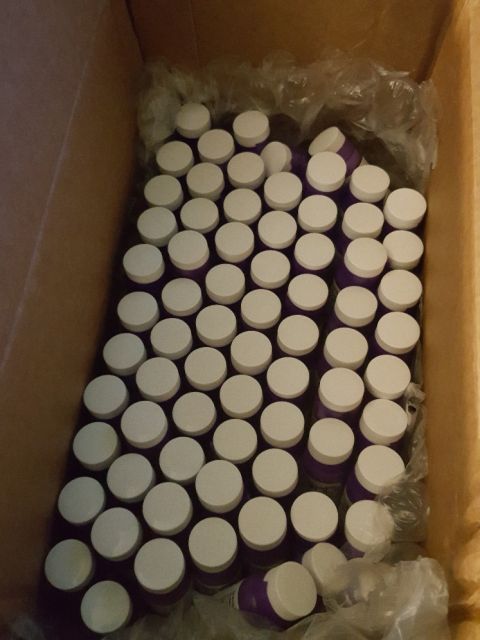 2007 Dodge Durango - A cardboard box is filled with numerous purple bottles topped with white caps.