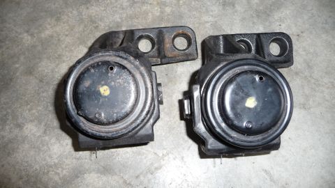 1993 Mazda MX-3 - Two engine mounts are shown resting on a concrete floor.