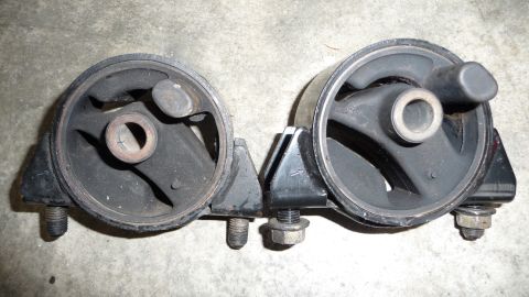1993 Mazda MX-3 - Two engine mounts are shown side-by-side on a concrete surface.