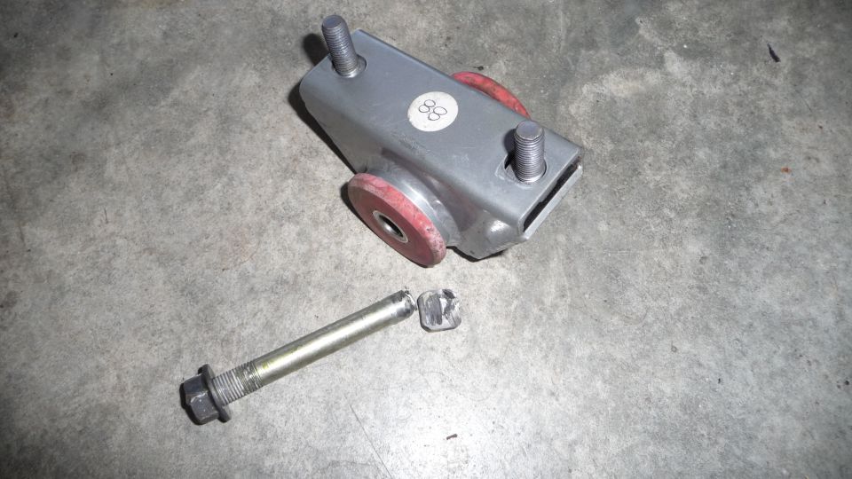 Engine mount with red bushings and a separate bolt. Sticker on mount reads '88'