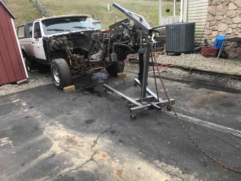 1992 Ford Bronco - This 1992 Ford Bronco is undergoing a tear-down, with its engine being hoisted out of the vehicle.