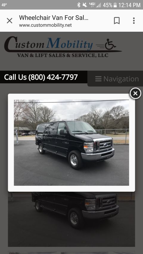 2010 Ford E250 - A black van is parked on an asphalt lot with trees in the background.