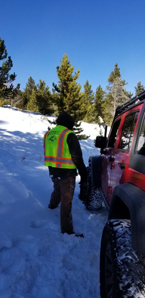 1996 Ford Bronco - A red Jeep Wrangler is partially visible in a snowy landscape, with a person in a safety vest standing nearby.