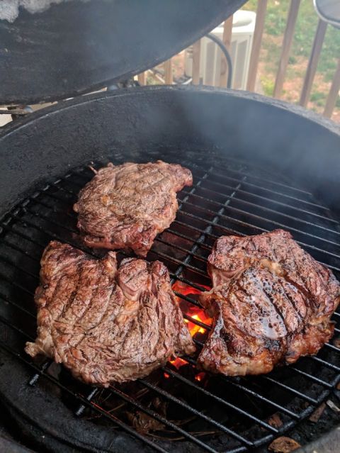 1979 Ford F-150 - Ribeye steaks grilling over coals on a backyard barbecue.