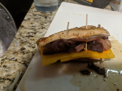 1979 Ford F-150 - A close-up of a sandwich with cheese and meat, prepared on a cutting board.