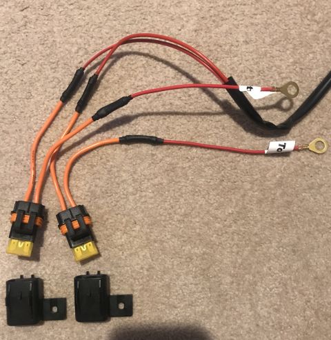 1995 Ford Bronco - A wiring harness assembly with multiple connectors, fuses, and ring terminals is laid out on a carpeted surface.