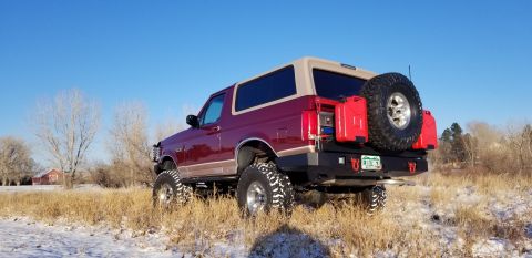 1996 Ford Bronco - This modified Ford Bronco sits in a snowy field under a clear blue sky.