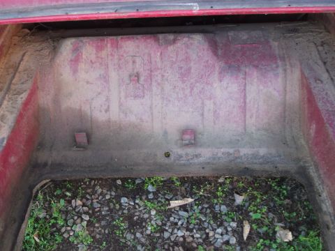 1970 Ford Torino - The interior of a car trunk shows signs of wear and tear, with dirt and debris covering the floor.