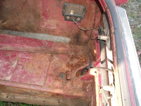 1970 Ford Torino - The interior of a car trunk shows significant rust and exposed wiring.
