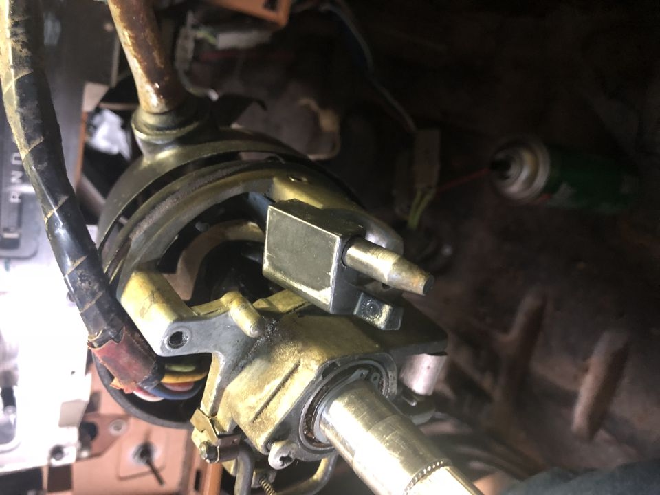 Close-up of vehicle steering column mechanism with wiring and spray lubricant.