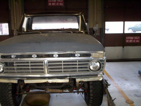 1978 Ford Bronco - Front view of a 1973 Ford F-Series truck grille in a garage setting.