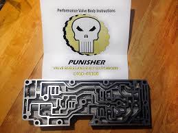 1996 Ford Bronco - A performance valve body for a transmission is displayed in front of a "Punisher Valve Body" instruction sheet. The valve body is made of m…