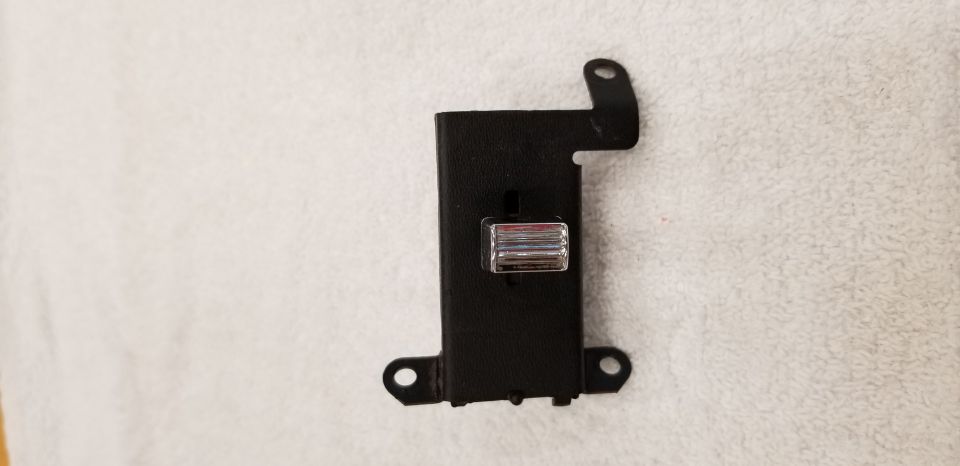Black plastic bracket with chrome slider switch