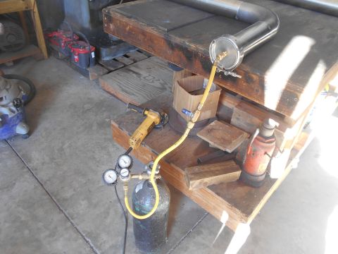1992 Ford Bronco - A metal pipe assembly is connected to a gas cylinder with a regulator and gauges. An angle grinder and a hydraulic jack are also visible on…