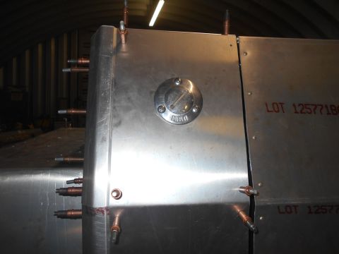 1992 Ford Bronco - A close-up view of a metal tank with several copper fittings protruding from its side. Red text reading "LOT 125771BG" is visible on the ta…