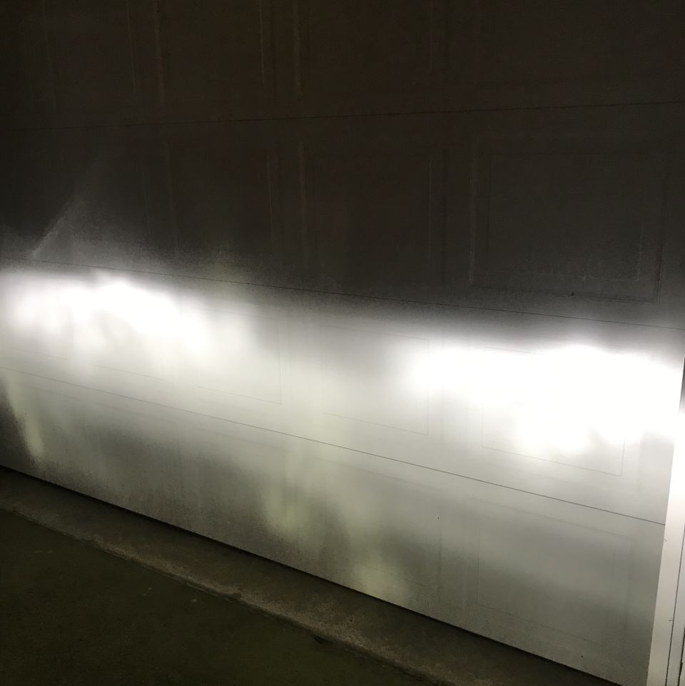 Headlights illuminating a garage door with a clear cutoff line.