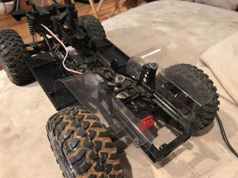 1989 Ford Bronco - A black remote control car is shown from a close-up angle, highlighting its tires and suspension.