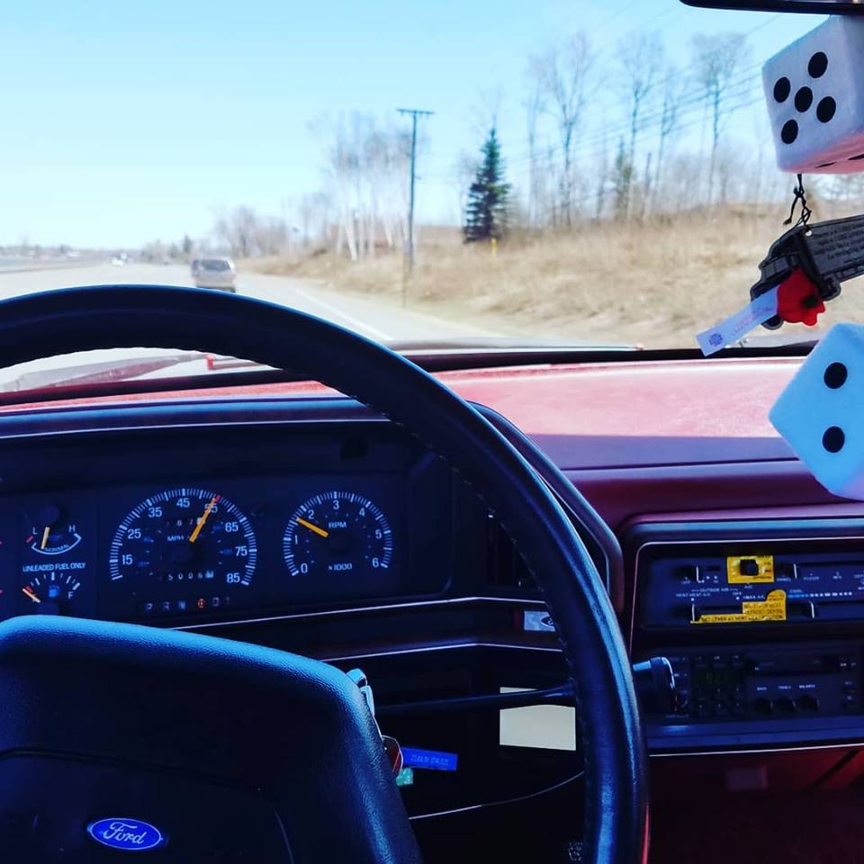 1988 Ford F-150 interior showing dashboard, steering wheel, and fuzzy dice hanging from rearview mirror