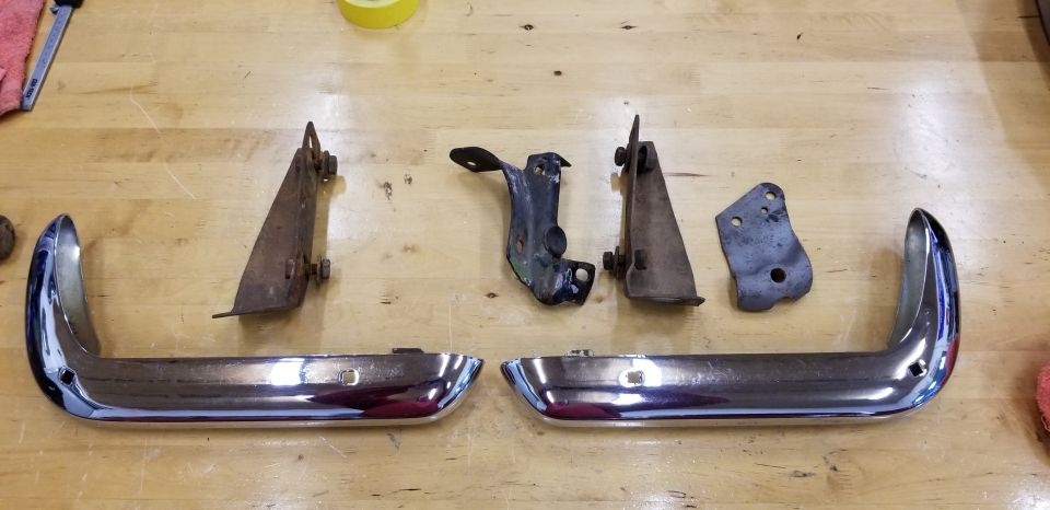 Chrome bumper guards and metal brackets on a wooden surface.