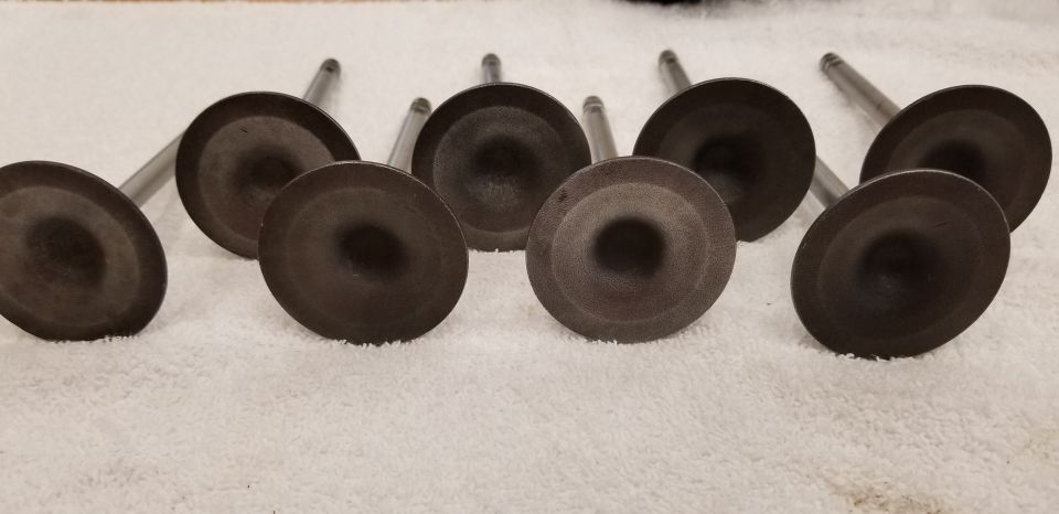 Eight engine valves on a white towel