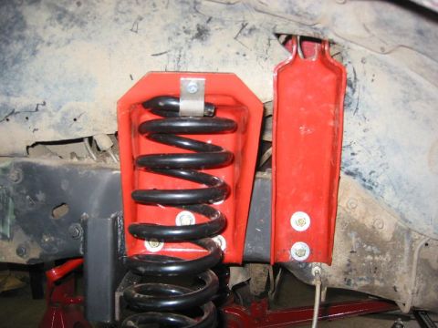 1985 Ford Bronco - Suspension coil spring and red bracket assembly, likely for off-road modification.