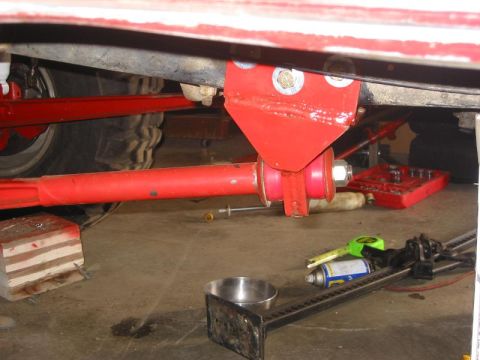 1985 Ford Bronco - Close-up view of modified suspension parts and a tire, with tools scattered around.