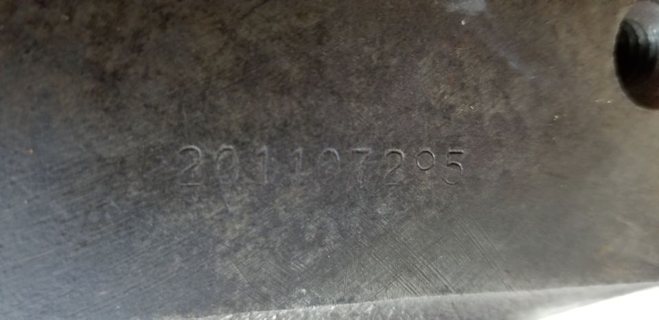 Stamped numbers 201107295 on a dark, textured surface.