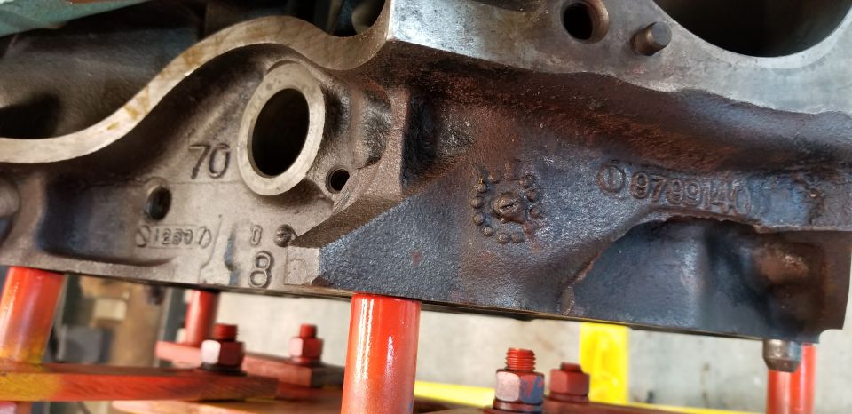 Close-up of a cast iron engine block with stamped numbers.