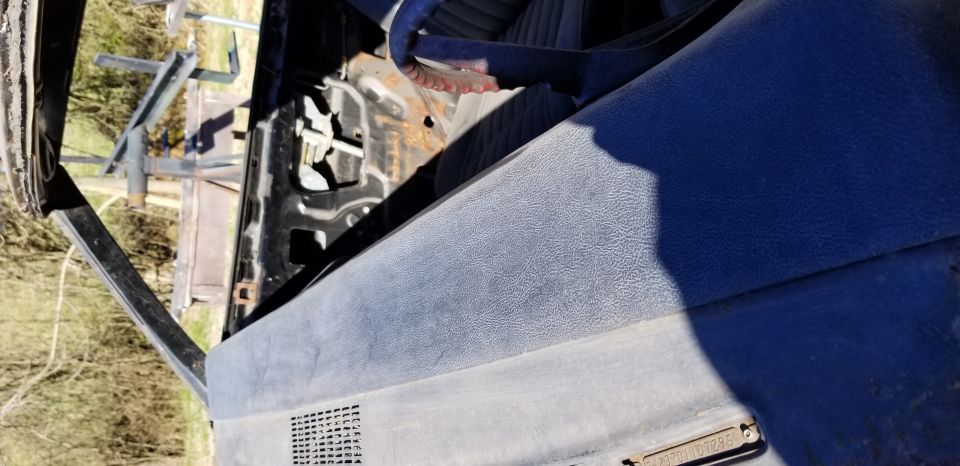 Close-up of a blue car dashboard with a VIN plate visible.