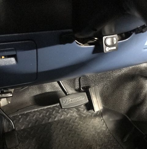 1995 Ford Bronco - Close-up of the driver's side footwell, showing the Bronco-branded pedal cover and brake pedal.