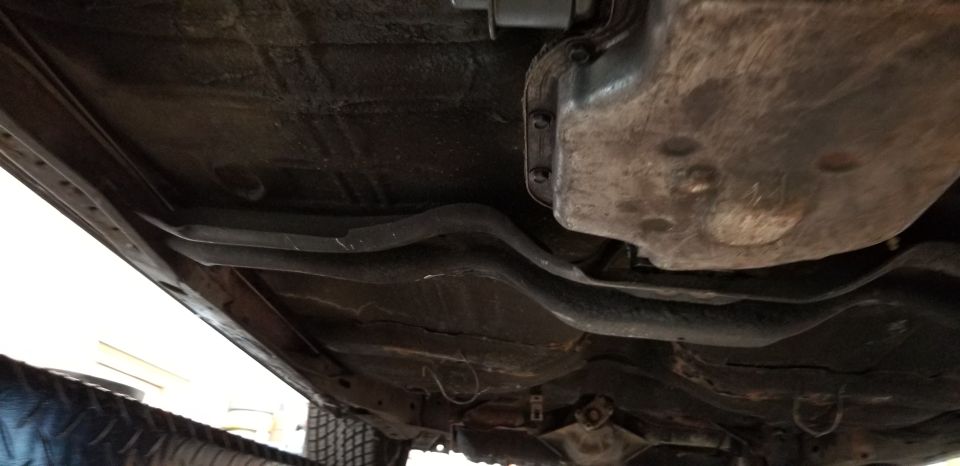 Underside view of a car showing the transmission and frame rails