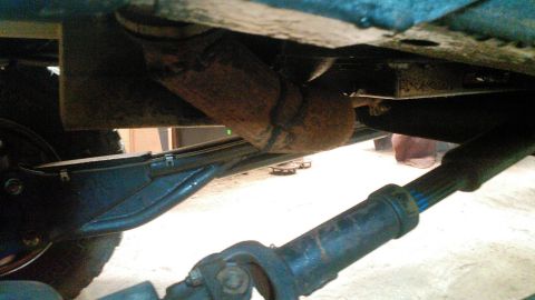 1978 Ford Bronco - This is an underside view of a vehicle, focusing on the suspension and exhaust components. A rusty exhaust pipe is visible, along with a dr…