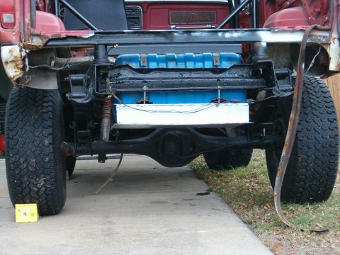 1979 Ford Bronco - The rear axle and a blue auxiliary fuel tank are visible on this red SUV.