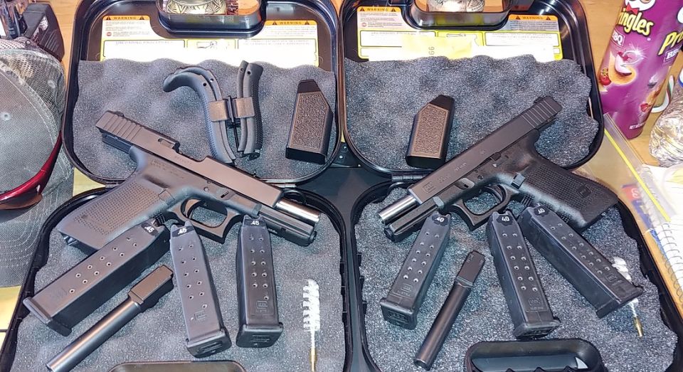 Two handguns in cases with extra magazines and cleaning supplies