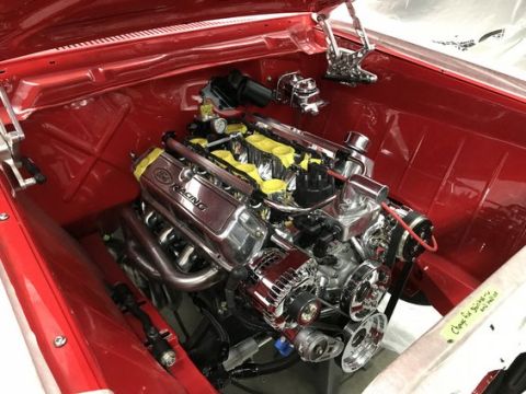 1964 Ford Fairlane - The engine bay of a red 1964 Ford Fairlane features a polished Ford Racing V8 engine with yellow accents on the intake runners. Chrome comp…