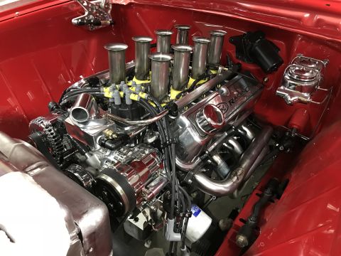 1964 Ford Fairlane - A highly polished chrome and aluminum V8 engine is installed in a red vehicle's engine bay. The engine features individual throttle bodies…