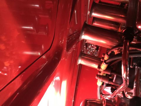 1964 Ford Fairlane - A close-up view of a highly polished chrome intake manifold with multiple carburetors on a red engine bay.