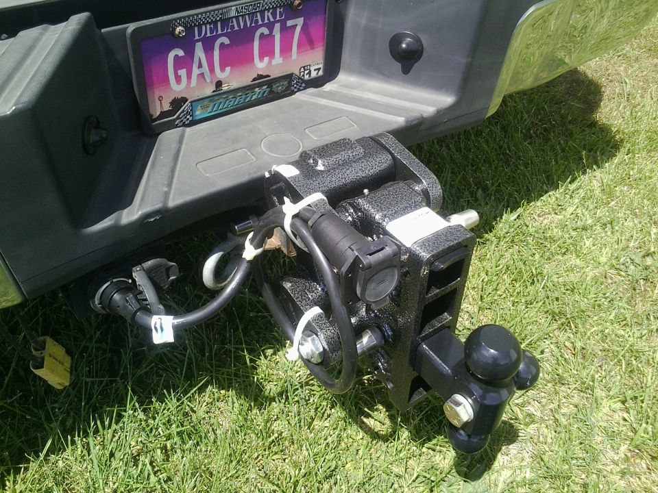Trailer hitch assembly with wiring harness connected to a vehicle bumper and license plate