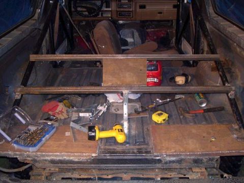 1979 Ford Bronco - Tools and materials are laid out inside a vehicle undergoing modifications, with a welding mask visible.