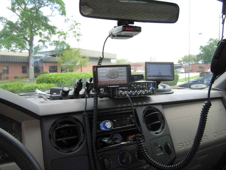 Dashboard of a Super Duty truck with CB radio, GPS, radar detector, and digital gauges mounted