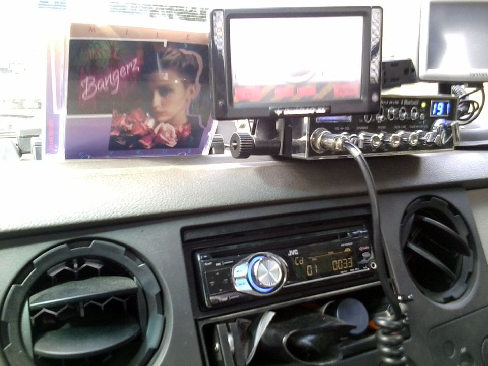 Dashboard with JVC CD player, CB radio, and a screen displaying a woman's face