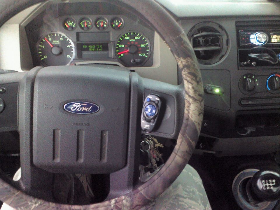 Ford F-Series truck interior showing dashboard, steering wheel with Ford logo, and instrument cluster with 555 miles to empty