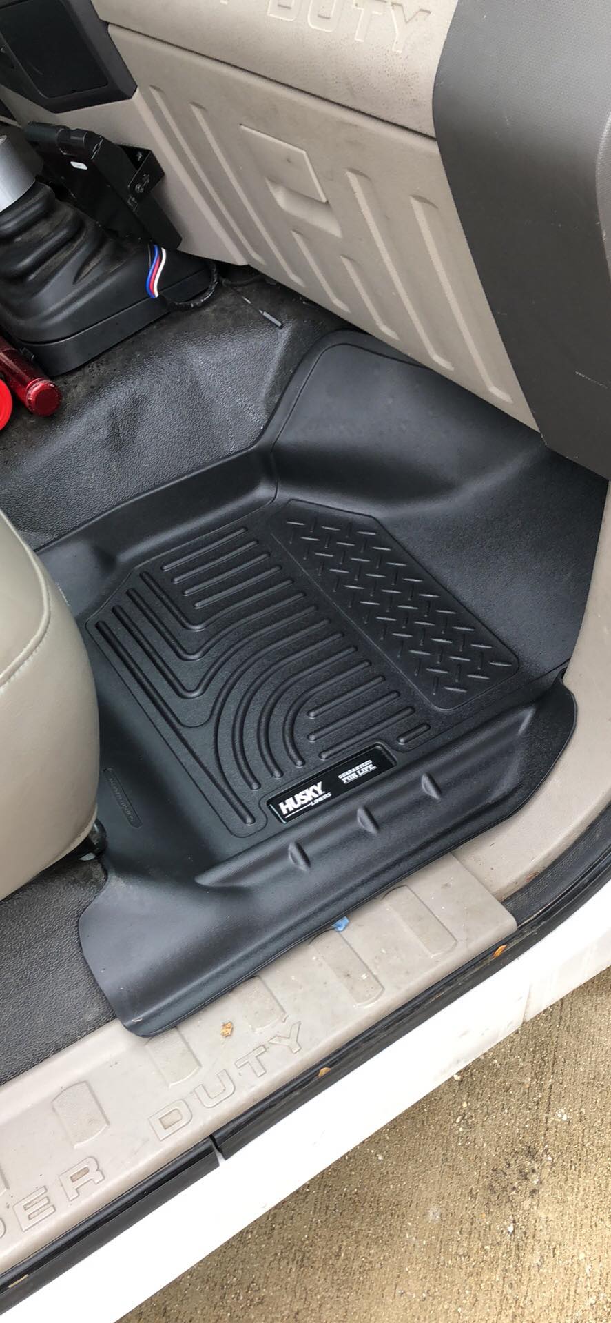 Ford Super Duty floor mats with Husky branding on the driver's side