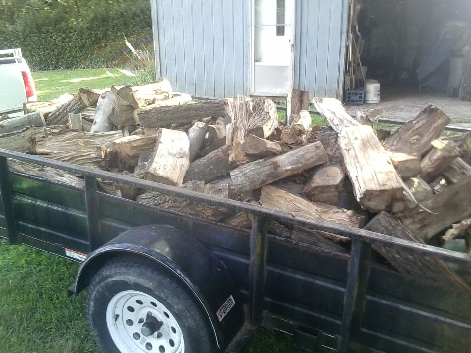 trailer loaded with cut logs and firewood