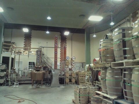2008 Ford F-250 - Interior view of a distillery showing large copper stills and numerous barrels stacked on pallets.