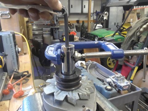 1985 Ford Bronco - Removing an alternator pulley with a socket wrench and C-clamp in a workshop.